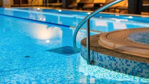 A swimming pool with a tiled edge and a hot tub area. - Chalet Birchwood With Hot Tub and Sauna (Breznički Hum)