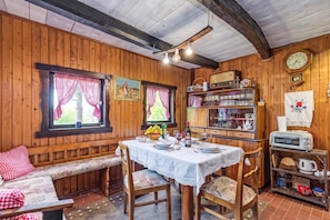 A wooden interior with a dining table set for two, a bench, and a shelf with various items. - Chalet Birchwood With Hot Tub and Sauna (Breznički Hum)