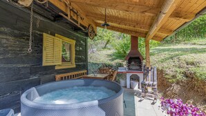 A rustic cabin with a hot tub, wooden deck, and a wood-burning stove. - Chalet Birchwood With Hot Tub and Sauna (Breznički Hum)