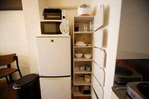 A compact kitchen with a refrigerator, microwave, and built-in oven.