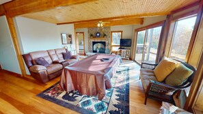 Una sala de estar acogedora con chimenea, un sofá, una mesa de comedor y una televisión.