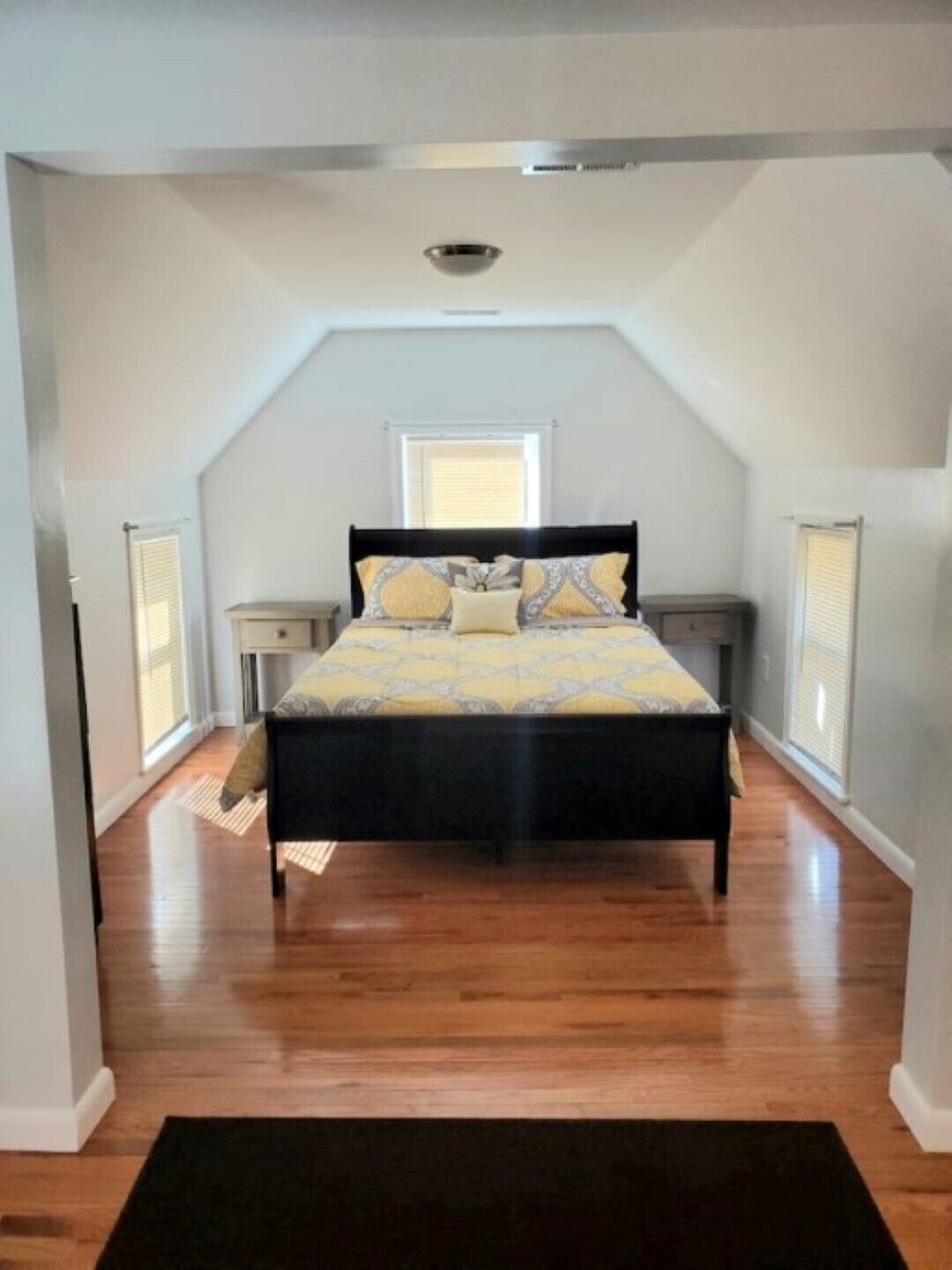 Een slaapkamer met een bed, nachtkastjes en een raam.