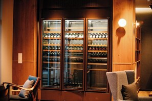 Relax in a cozy seating area with a wine storage cabinet and comfortable chairs.