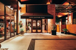 L’entrée de l’hôtel Karuizawa Cross se distingue par son design moderne, avec une façade en briques et de grandes portes vitrées qui mettent en valeur l’entrée.
