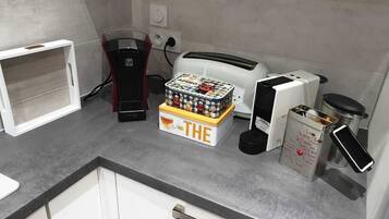 Una encimera de cocina con cafetera, tostadora y una caja con la etiqueta 'THE'.