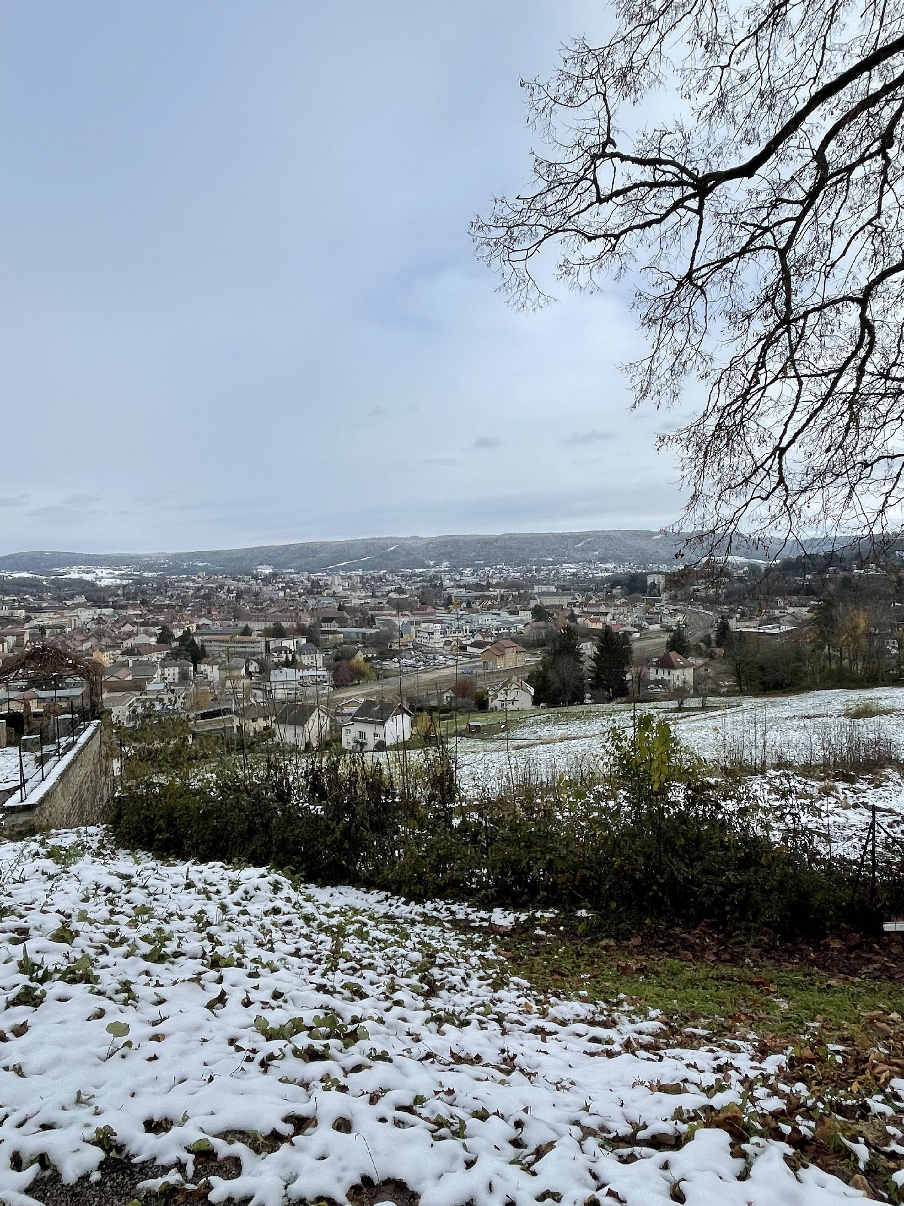 A panoramic view of a town with snow-covered fields and buildings.
