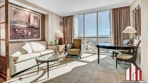 A spacious living room with a large window, a sofa, a coffee table, and a dining table. - MGM Signature-11-604 Jacuzzi Studio (Las Vegas)