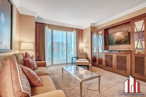 A spacious living room with a sofa, a coffee table, and a television on a wooden cabinet.