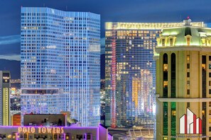 A cityscape with modern high-rise buildings, including a prominent glass skyscraper and a historic building with a green roof.
