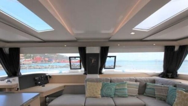 Un interior moderno con un sofá, una mesita y vistas al mar.