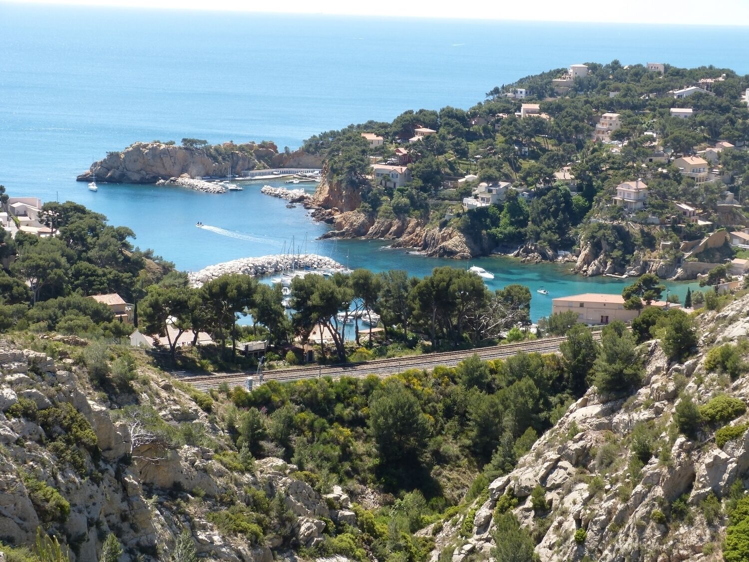 Une ville côtière au paysage rocheux, dotée d’un port de plaisance et de bâtiments à l’architecture méditerranéenne.