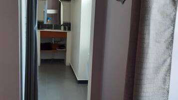 A hallway leading to a kitchen with a visible countertop and cabinets.