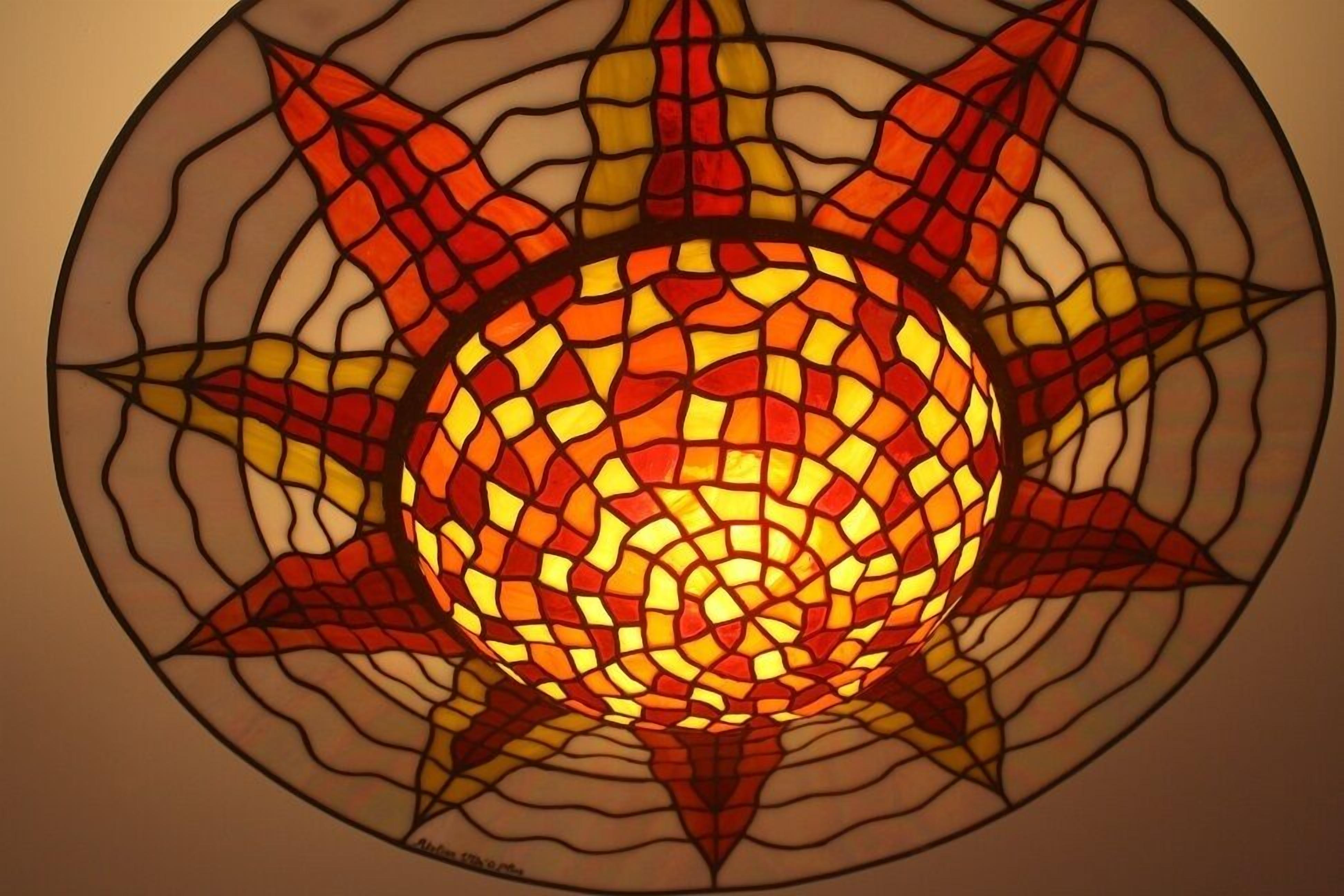 A circular stained glass window with a sun design.