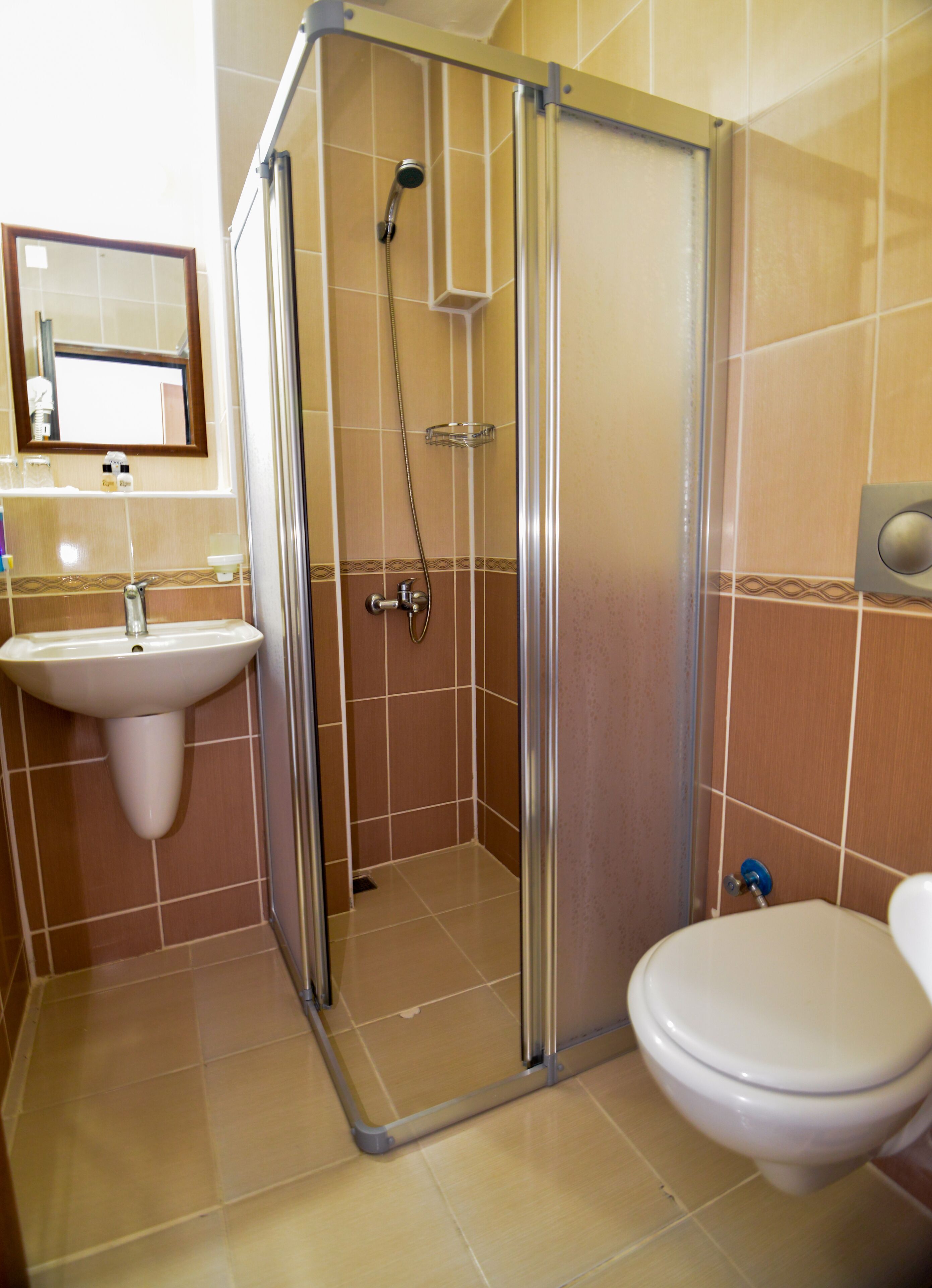 A bathroom with a glass-enclosed shower, a sink, and a toilet.