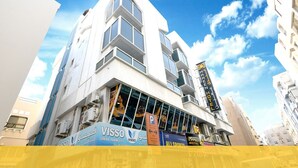 A modern hotel with a prominent 'Marriott Hotel' sign, large windows, and a visible 'VISSO' sign indicating a nearby business. - Maaeen Hotel (Dubai)