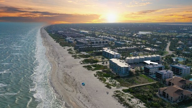 Ein Küstenresort mit Strandvillen, einer Promenade und einem Jachthafen.