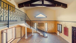 A spacious interior with a grand staircase, a skylight, and a high ceiling. - Villa Clara – Country Retreat (Siracusa)
