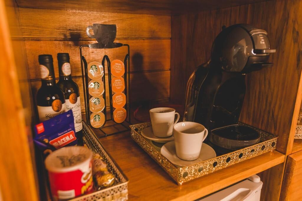 Un coin café équipé d’une machine à café, de tasses et d’un plateau de viennoiseries.