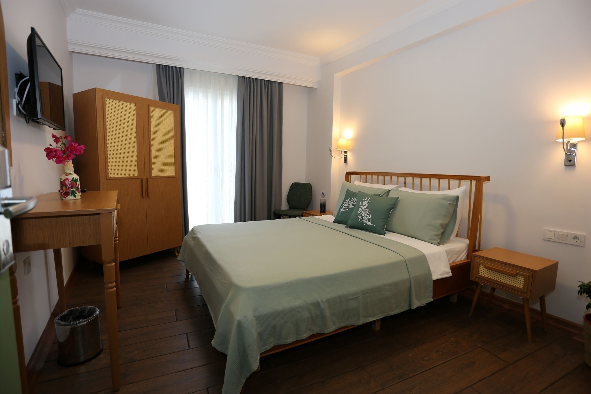 Une chambre d’hôtel équipée d’un lit, d’un bureau, d’une armoire et d’un téléviseur.