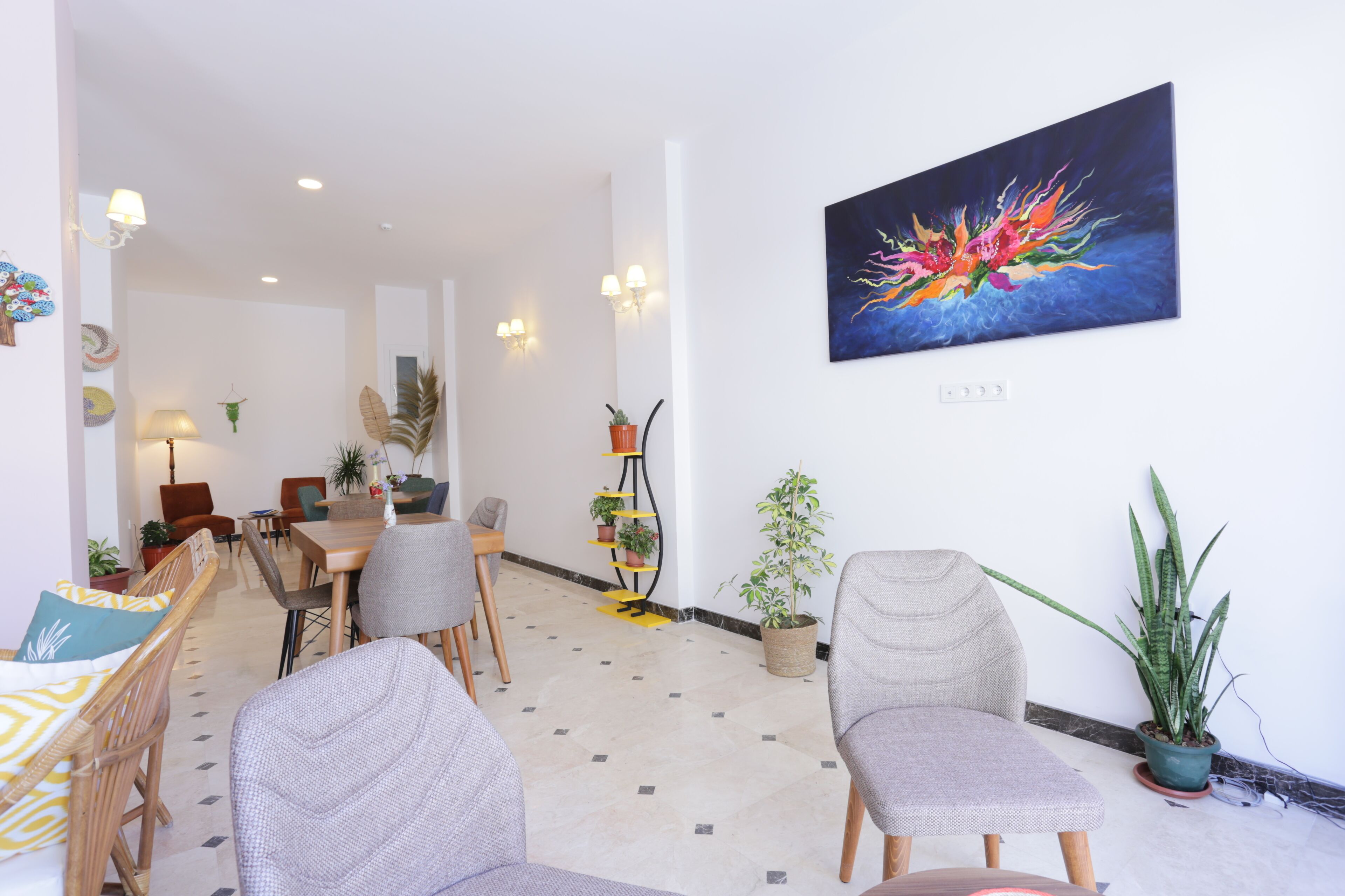 A modern living room with a dining area, featuring a sofa, chairs, a coffee table, and a potted plant.