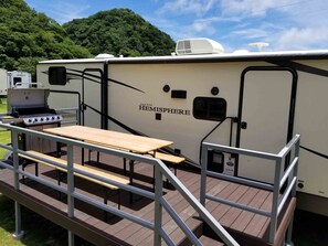 Una vehículo recreativo con mesa de picnic y zona de barbacoa.