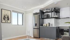 Una cocina moderna con armarios grises, un refrigerador de acero inoxidable y un horno empotrado.