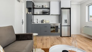 A modern kitchen with grey cabinets, a white countertop, and stainless steel appliances. - Point Break | Ocean Views | Walk to VandA | Pool (Cape Town)