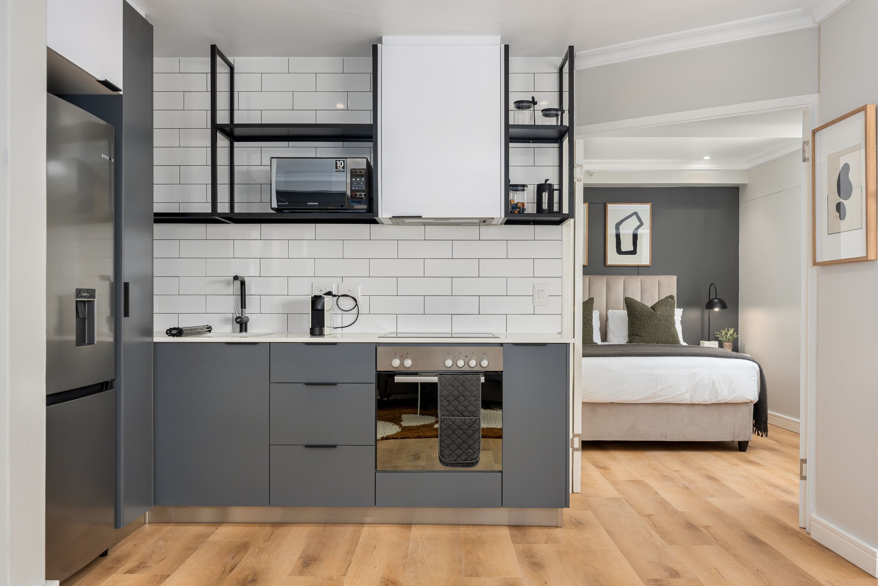 A compact kitchen with a built-in oven, a microwave, and a refrigerator.