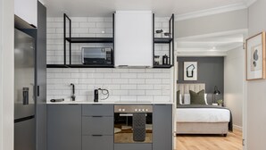 Una cocina compacta con horno integrado, microondas y refrigerador.