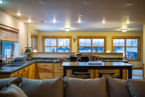 A kitchen with wooden cabinets, a central island, and large windows.