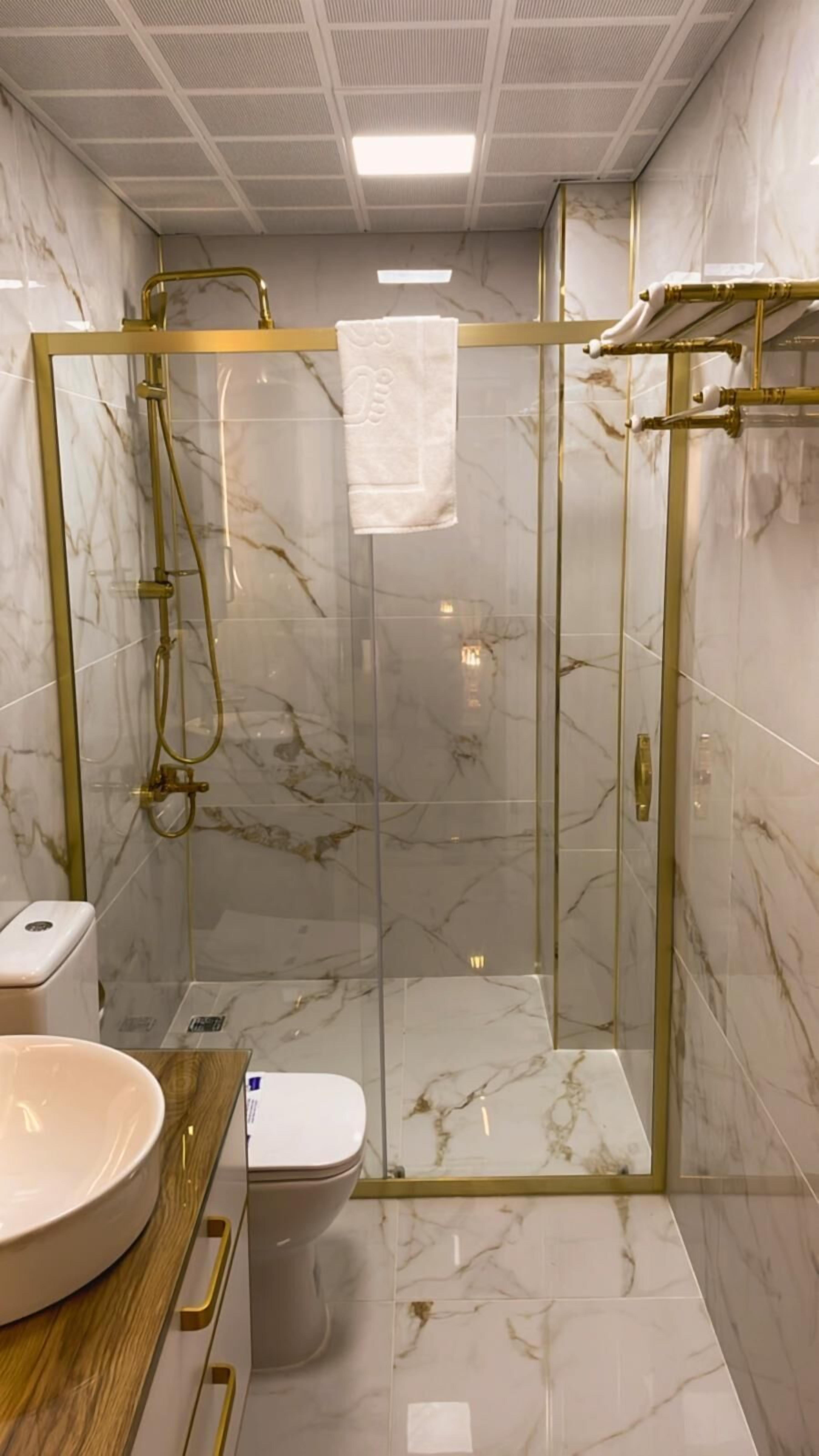 luxury studio suite | bathroom | shower, rainfall showerhead, hair dryer, towels