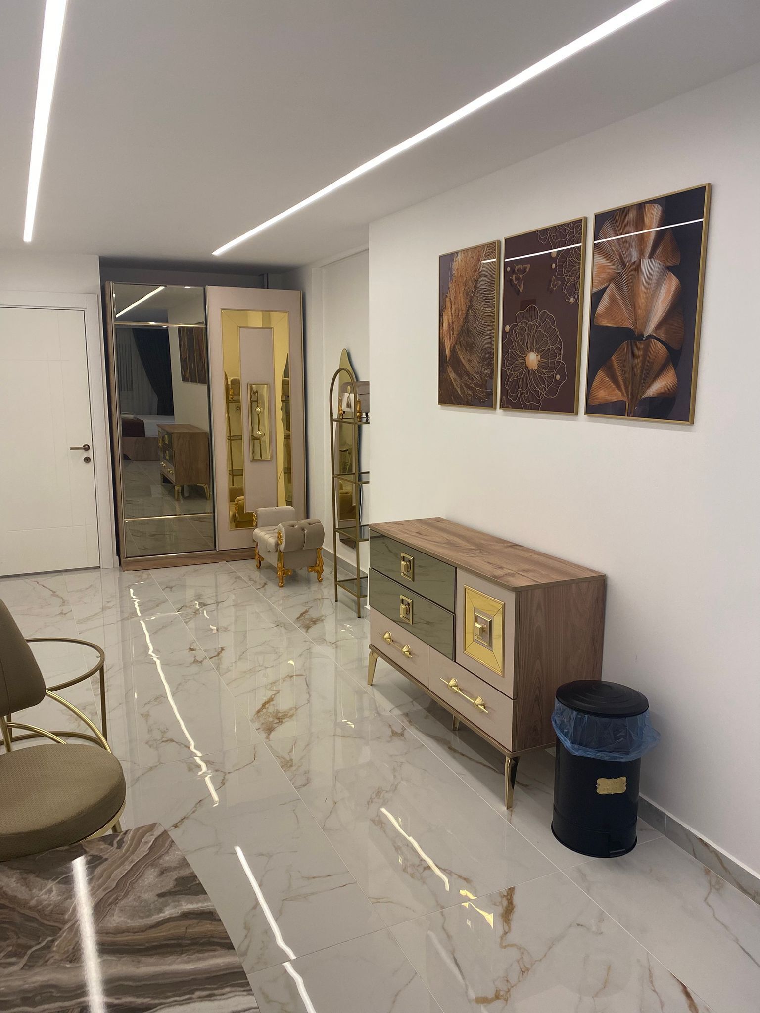 A modern living room with a marble floor, a wooden cabinet, and a mirror.