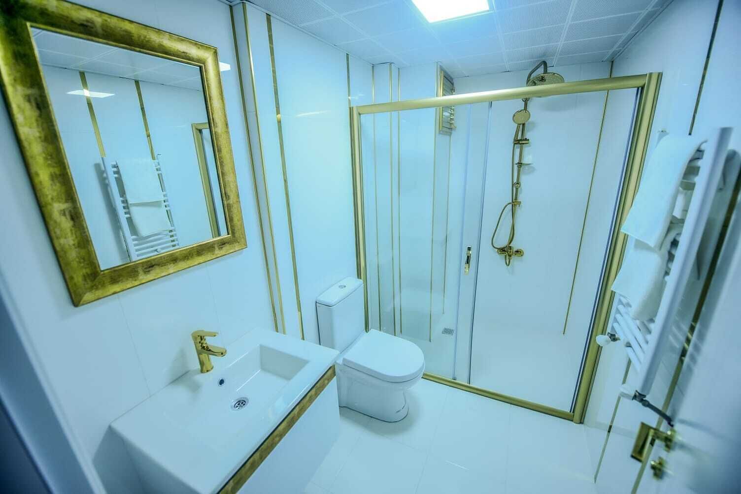Un baño moderno con lavamanos, inodoro y ducha blancos.