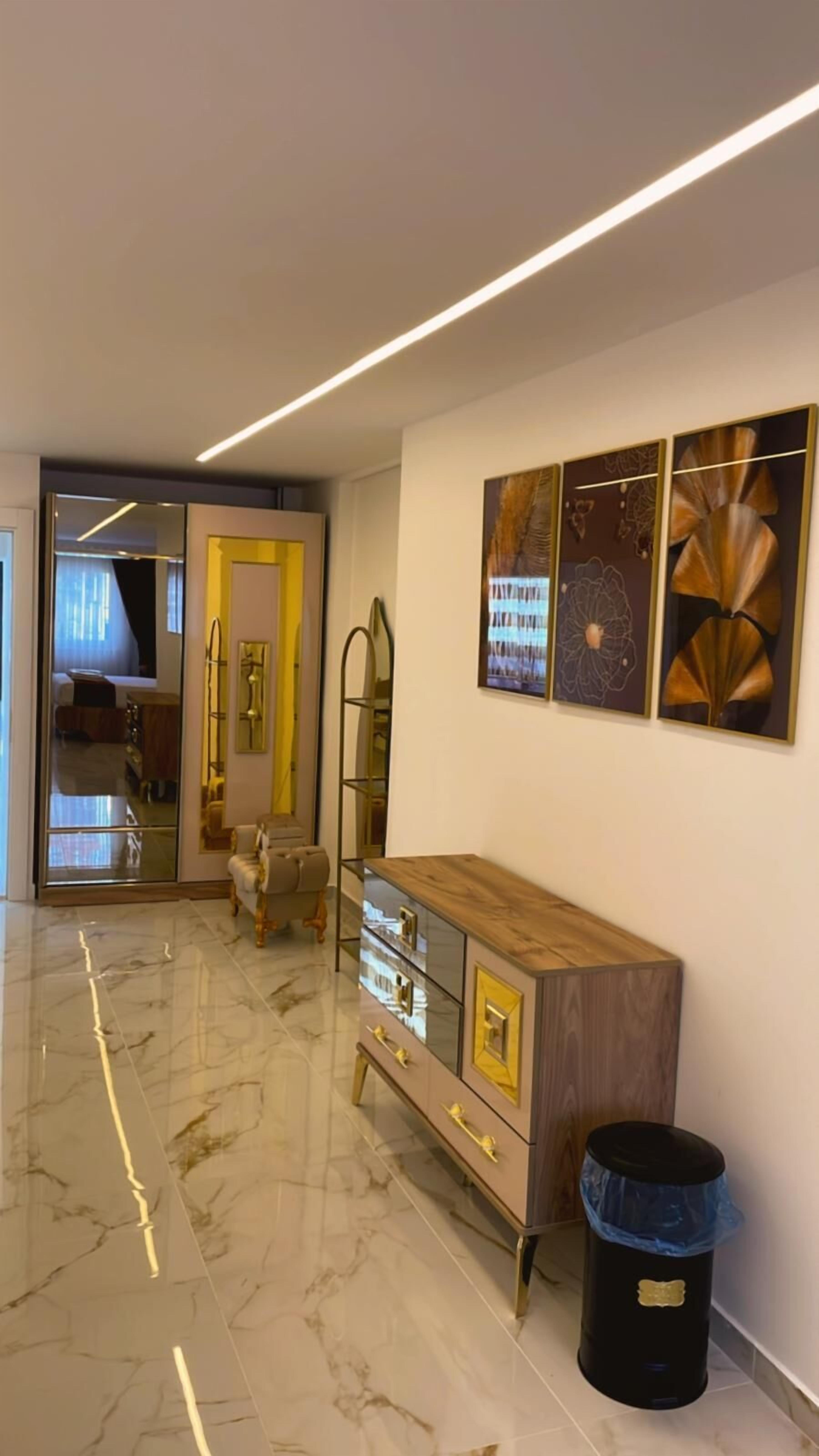 Un interior moderno con suelo de mármol, un armario de madera y arte abstracto en la pared.
