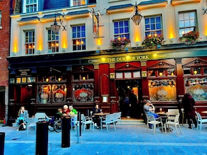 A building with a sign reading "The Duke of York" and a bar and dining area on the first floor. - RARE SUMMER OUTSIDE SPACE SW1! WALK TO BUCK PALACE, RIVER, METROS, CAFES & PUBS! (London)