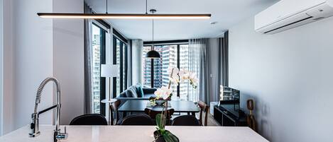 A modern kitchen with a marble countertop, a built-in sink, and a pendant light.
