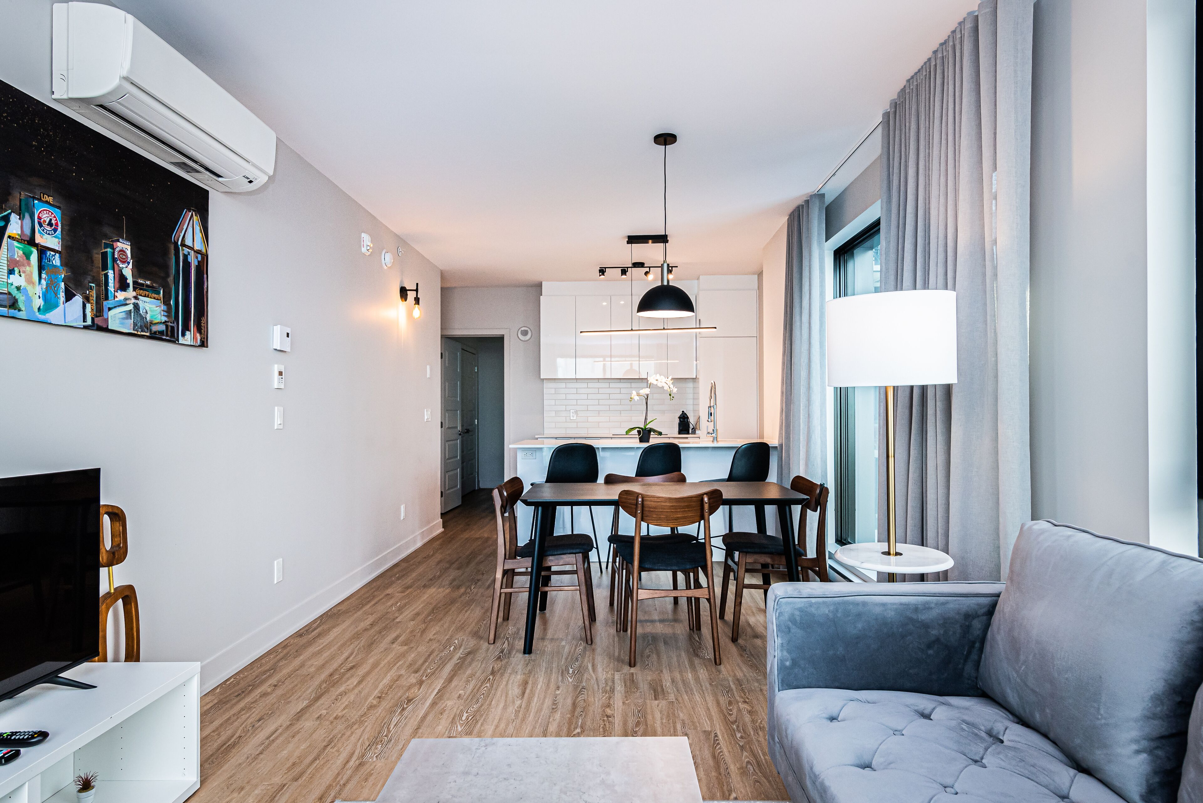 A modern living room with a TV, sofa, and dining area.