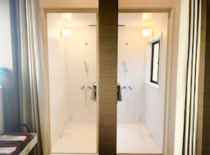 A modern bathroom with a shower, a towel rack, and a window.