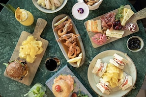 Diversos alimentos como sanduíches, batatas fritas e frutos do mar sobre uma mesa.