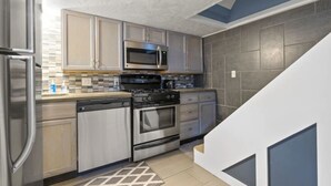 A modern kitchen with stainless steel appliances, a microwave, oven, and dishwasher.