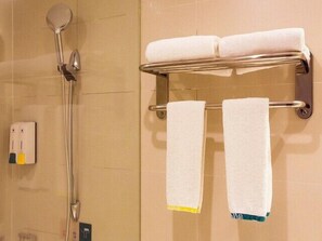 Bany amb dutxa, una barra de tovalloles i dues tovalloles, i un dosificador de sabó.