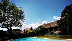 A swimming pool with a clear blue water, surrounded by trees and houses. - La Grange d'Eugénie - Chez Marcelle and Eugénie (Saint-Léger-sur-Dheune)