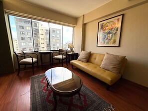 A living room with a sofa, chairs, a coffee table, and a rug.