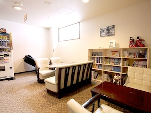 A library with bookshelves, a small table, and two chairs.