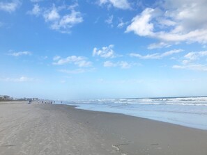 A beach with a clear sky and waves.