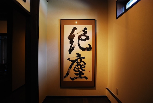 A framed calligraphy artwork on a wall in a hallway.