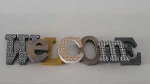 A wall with the word "Welcome" spelled out in variously patterned letters. - T2 near historic center (Manosque)