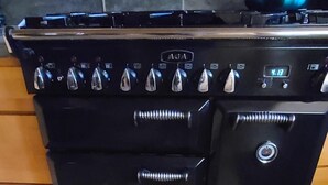 A black stove with a digital clock displaying 4:13, a kettle on top, and a tiled floor. - Spacious cabin in Angel Fire area - 6 miles to ski slopes and recreation area (Angel Fire)