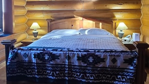 A log cabin room with a bed, two bedside lamps, a ceiling fan, and a dreamcatcher. - Spacious cabin in Angel Fire area - 6 miles to ski slopes and recreation area (Angel Fire)
