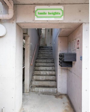 A stairway leading to an upper level with a sign reading "Smile heights".